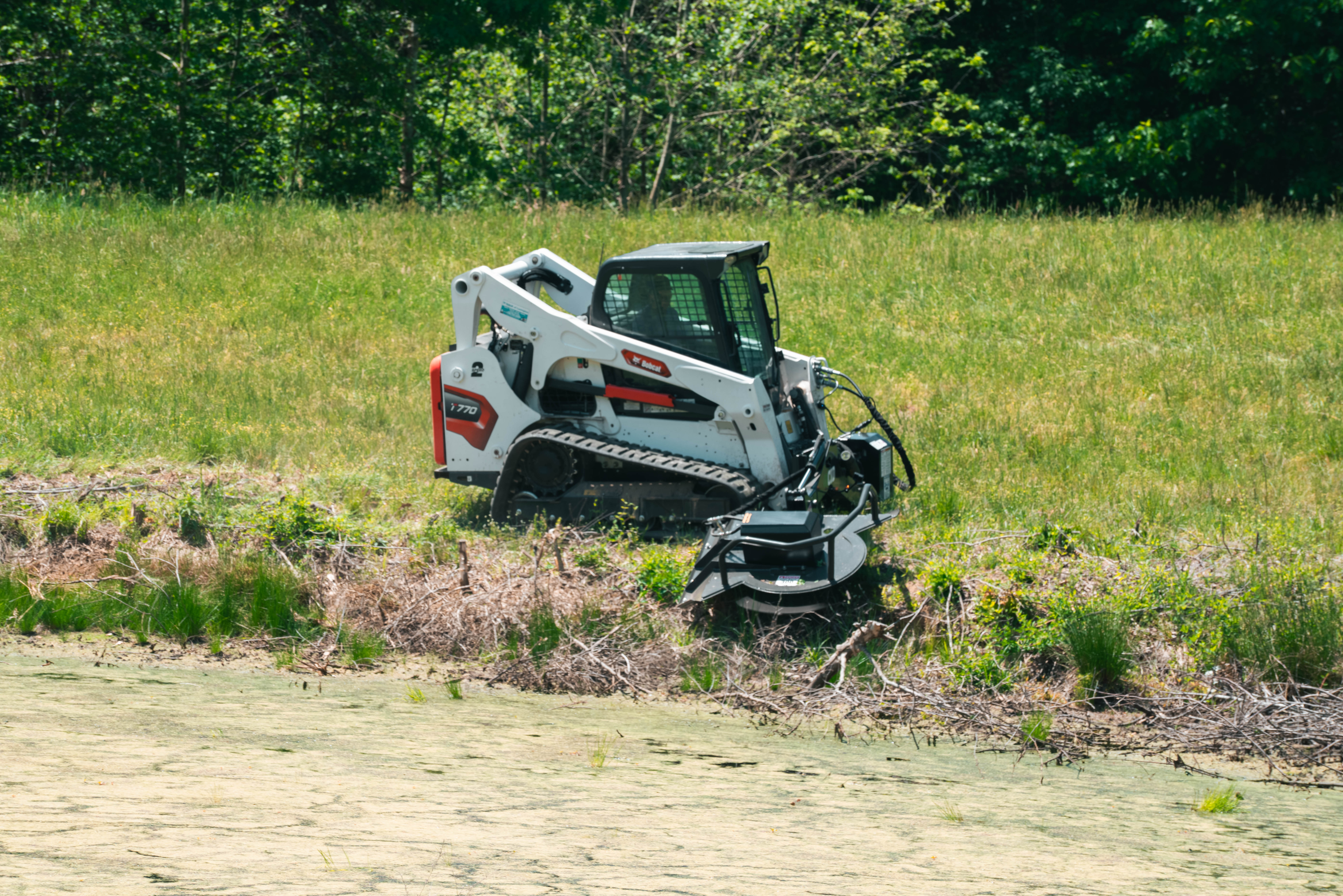 Commercial and government skid steer and excavator attachments from CID, including swing boom brush cutters, grapples, buckets, and severe duty vegetation management equipment for municipal, DOT, forestry, and commercial fleet operations.