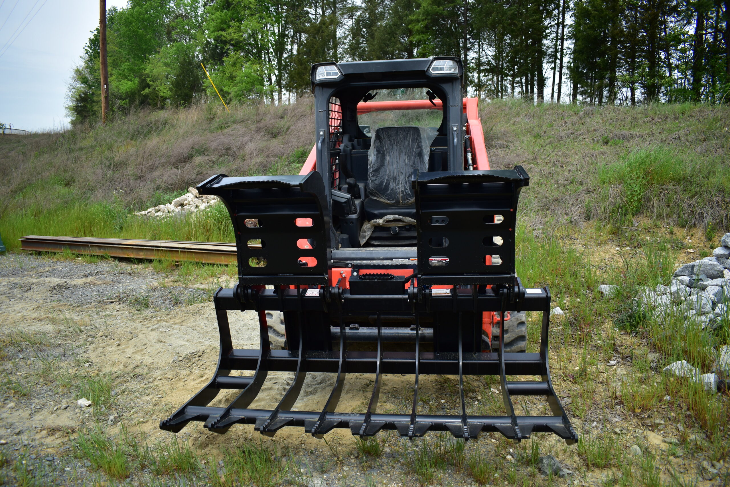Commercial and government skid steer and excavator attachments from CID, including swing boom brush cutters, grapples, buckets, and severe duty vegetation management equipment for municipal, DOT, forestry, and commercial fleet operations.